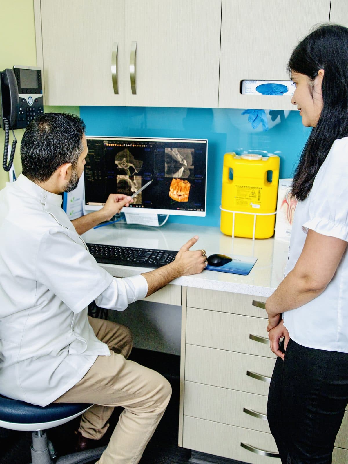 A dentist discussing All-On-4 dental implant treatment with a patient.