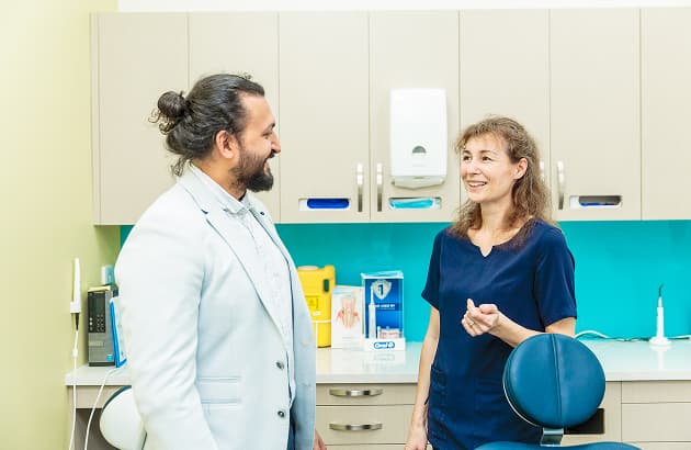 A Dapto dentist showing a patient a dental model inside the clinic.