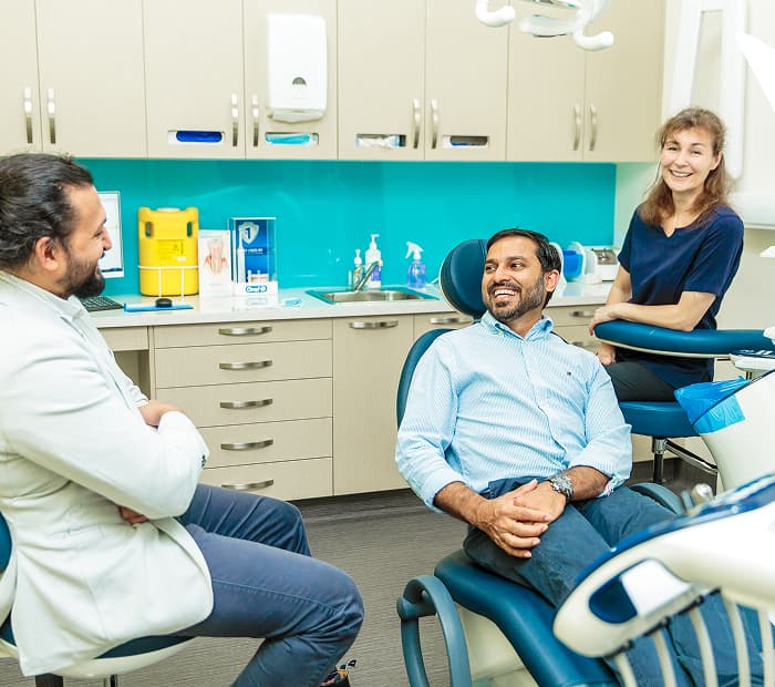 A dentist discussing dental implant treatment with a patient.