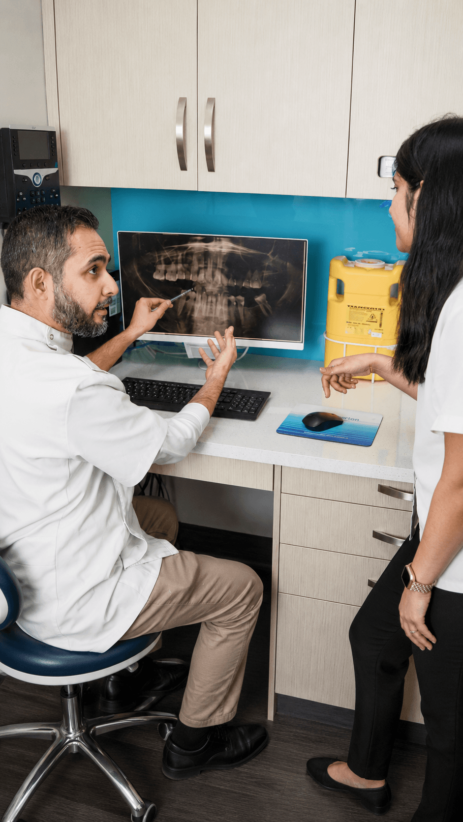 A dentist reviewing information with a person during a consultation.